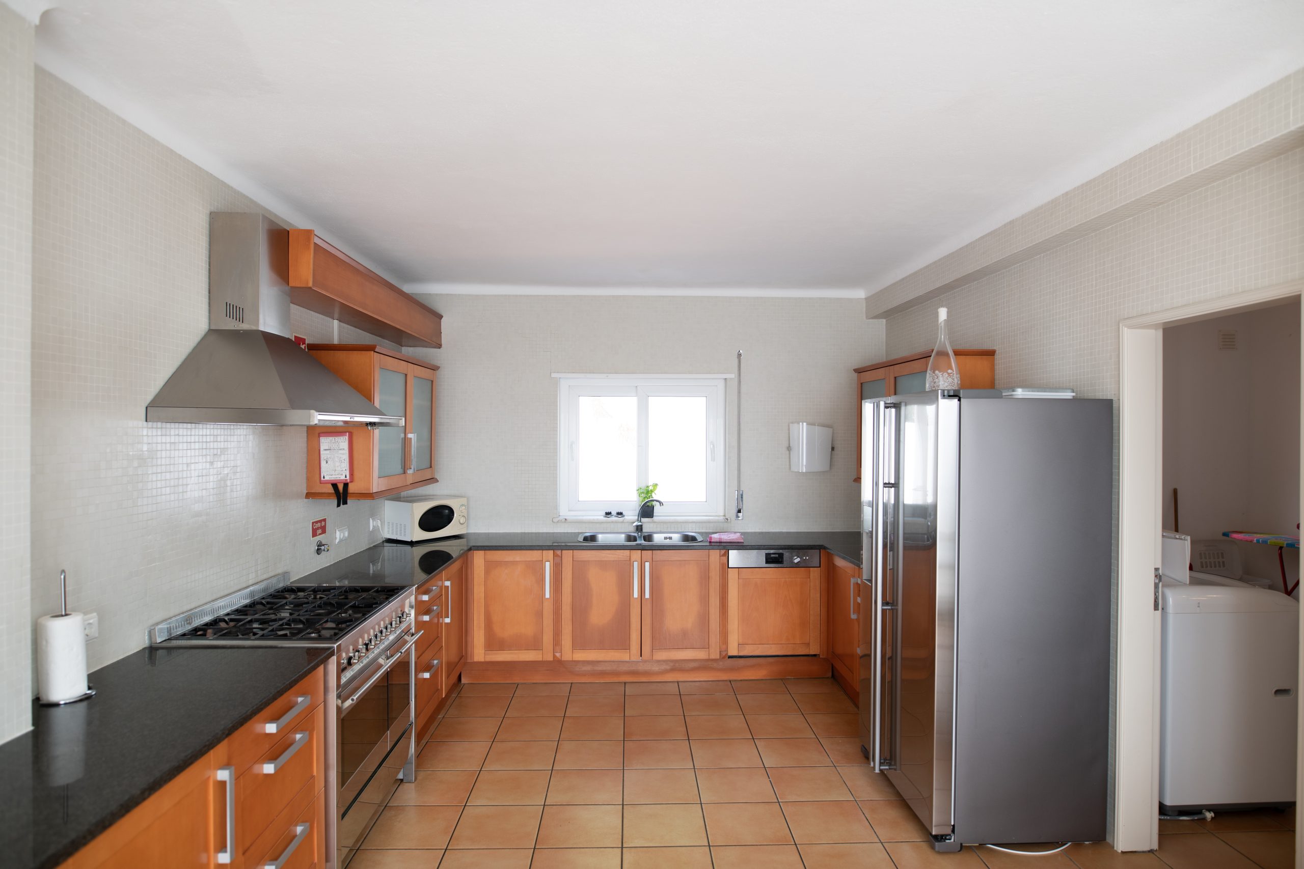 Large but outdated kitchen with wooden cabinets and granite counter top